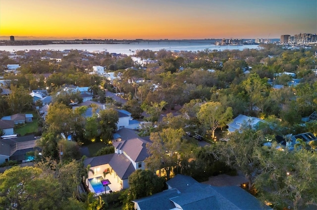 aerial view at dusk featuring a water view