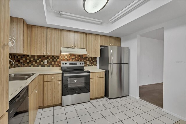 kitchen with sink, light tile patterned floors, tasteful backsplash, and appliances with stainless steel finishes