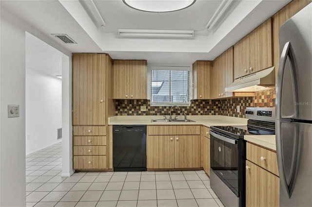 kitchen with stainless steel appliances, a raised ceiling, tasteful backsplash, light tile patterned flooring, and sink