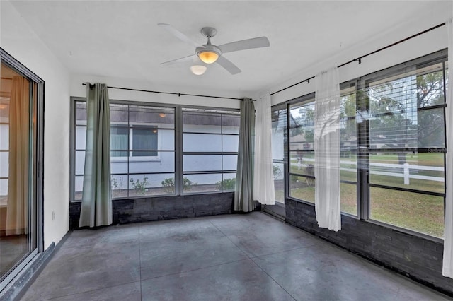 unfurnished sunroom with a healthy amount of sunlight and ceiling fan