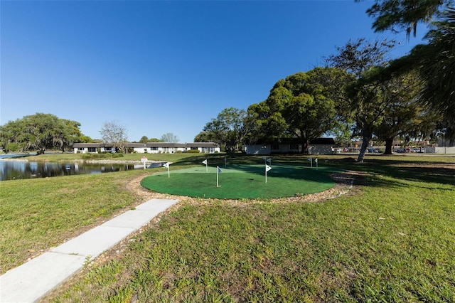 view of property's community with a water view and a lawn