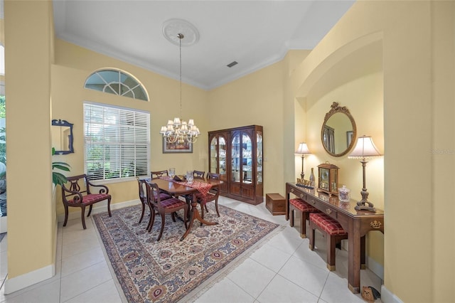 dining area with an inviting chandelier, light tile patterned floors, and ornamental molding