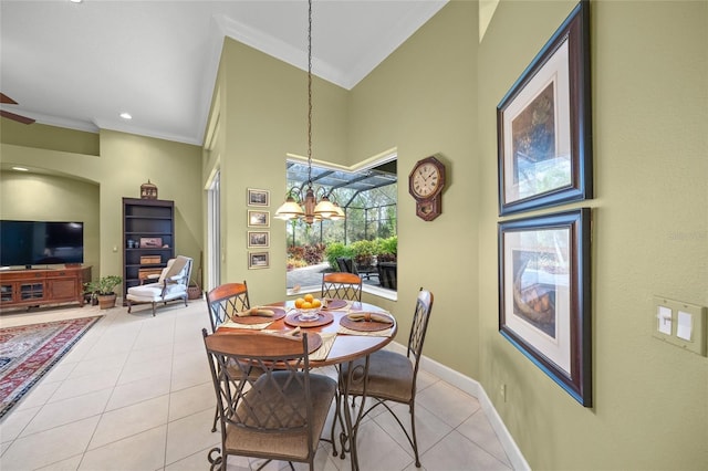 dining space with light tile patterned flooring, ornamental molding, and a chandelier