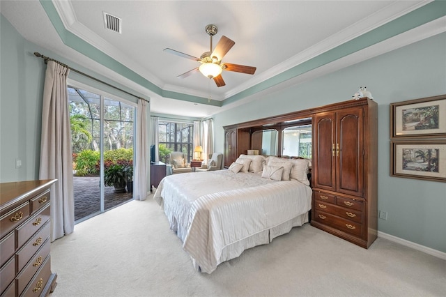 carpeted bedroom with access to outside, ceiling fan, crown molding, and a tray ceiling