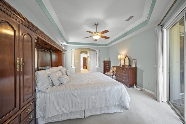 bedroom featuring ceiling fan, access to exterior, ornamental molding, a tray ceiling, and light colored carpet