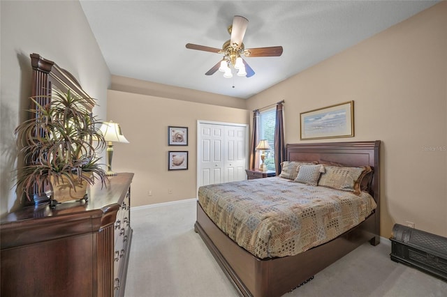 bedroom featuring ceiling fan, light carpet, and a closet