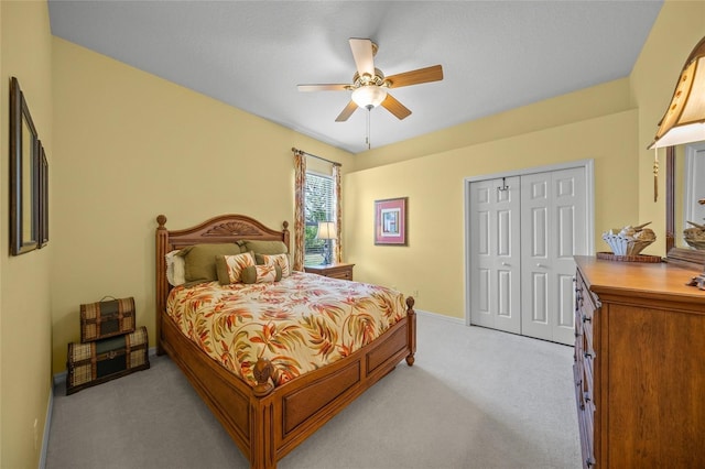 carpeted bedroom with ceiling fan and a closet