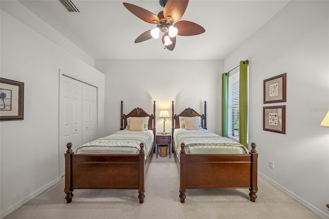 bedroom featuring ceiling fan, light carpet, and a closet