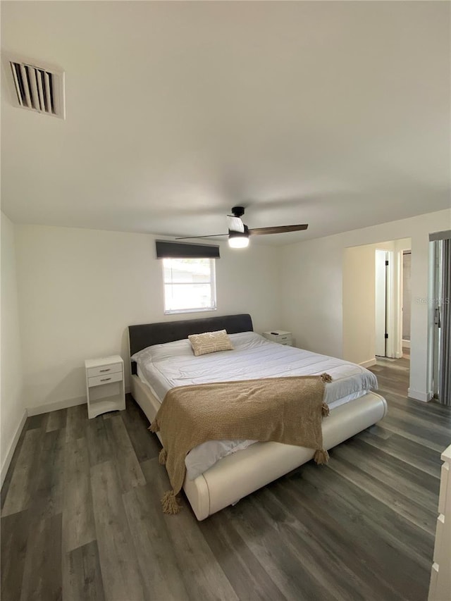 bedroom with dark hardwood / wood-style flooring and ceiling fan