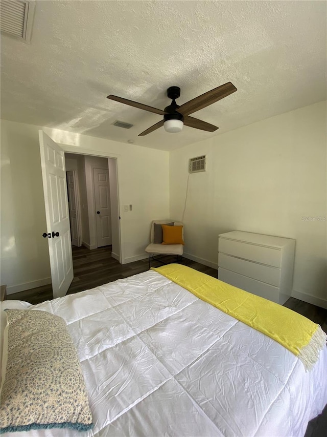 bedroom featuring hardwood / wood-style flooring, a textured ceiling, and ceiling fan