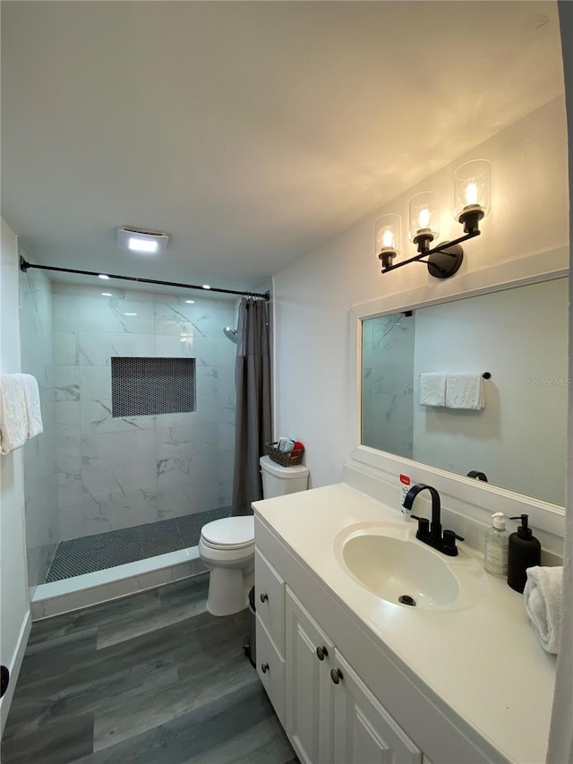 bathroom featuring walk in shower, vanity, toilet, and wood-type flooring