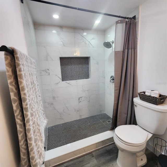 bathroom featuring wood-type flooring, toilet, and curtained shower