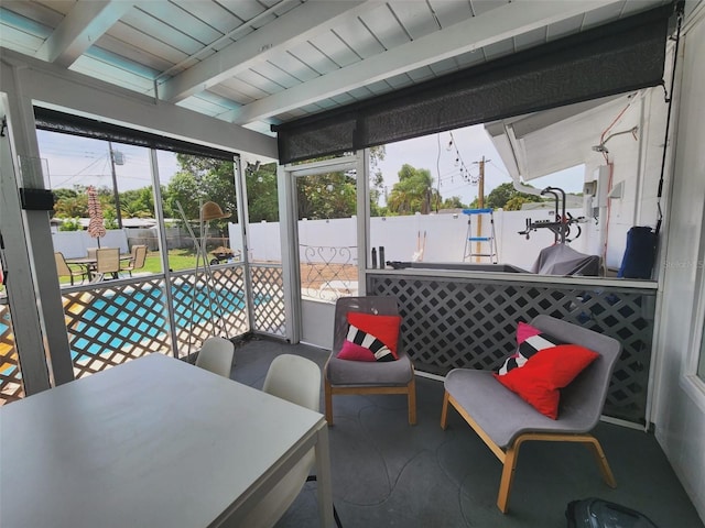 sunroom / solarium featuring beamed ceiling