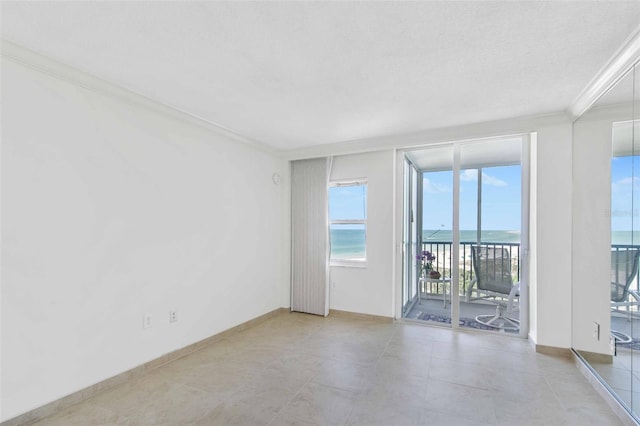 spare room featuring crown molding and a water view