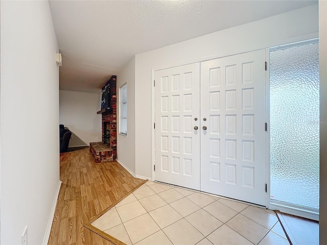 entrance foyer with light hardwood / wood-style floors and a textured ceiling