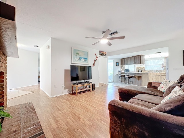 living room featuring ceiling fan and light wood-type flooring