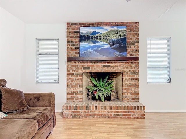 living room featuring light wood-type flooring and a brick fireplace