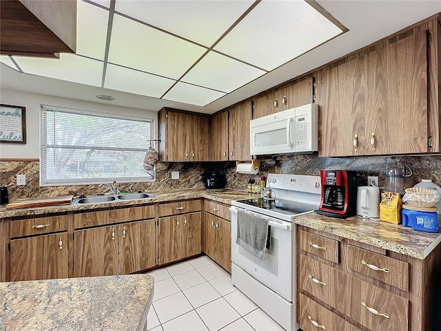 kitchen with backsplash, sink, light tile patterned flooring, and white appliances