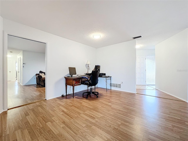 office featuring a textured ceiling and light hardwood / wood-style flooring