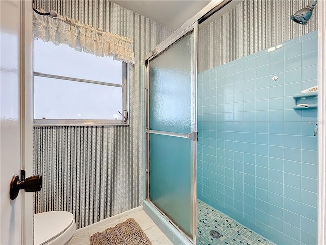 bathroom with tile patterned flooring, toilet, and a shower with shower door