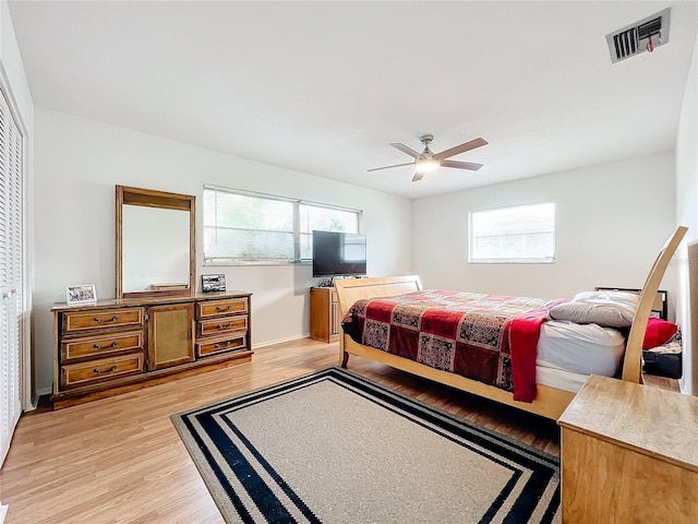 bedroom featuring multiple windows, light wood-type flooring, a closet, and ceiling fan