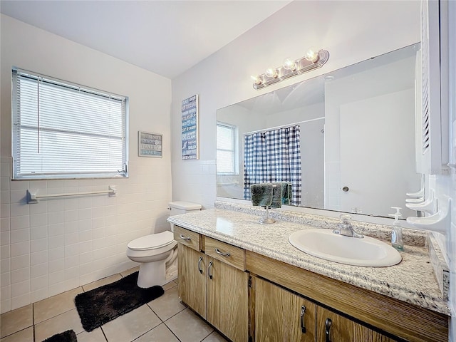 bathroom featuring a shower with shower curtain, tile patterned floors, vanity, tile walls, and toilet