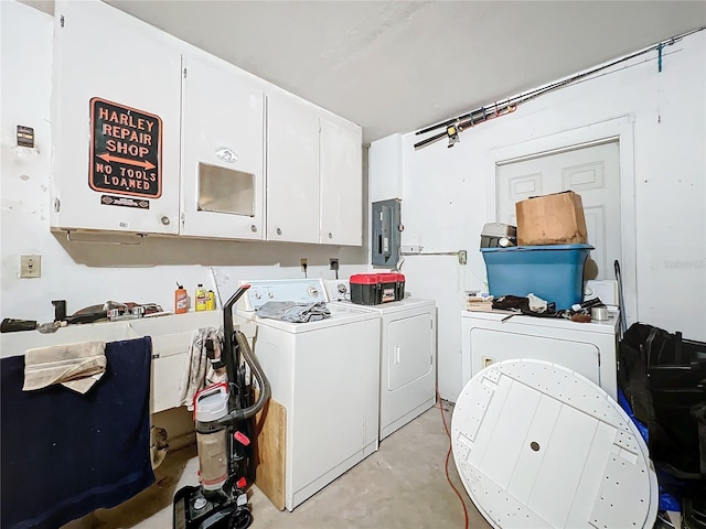 washroom with separate washer and dryer, electric panel, and cabinets