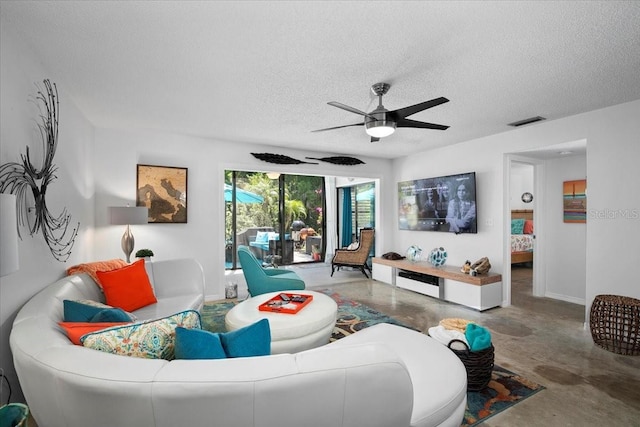 living room with a textured ceiling, concrete floors, and ceiling fan