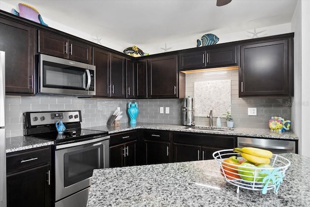 kitchen with backsplash, dark brown cabinets, sink, and appliances with stainless steel finishes