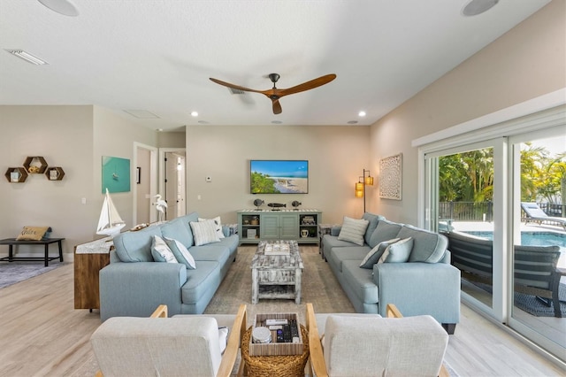 living room featuring light hardwood / wood-style flooring and ceiling fan