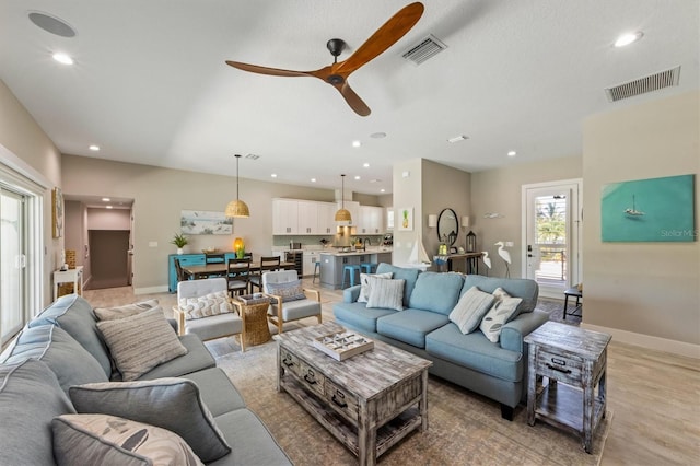 living room featuring light hardwood / wood-style flooring and ceiling fan