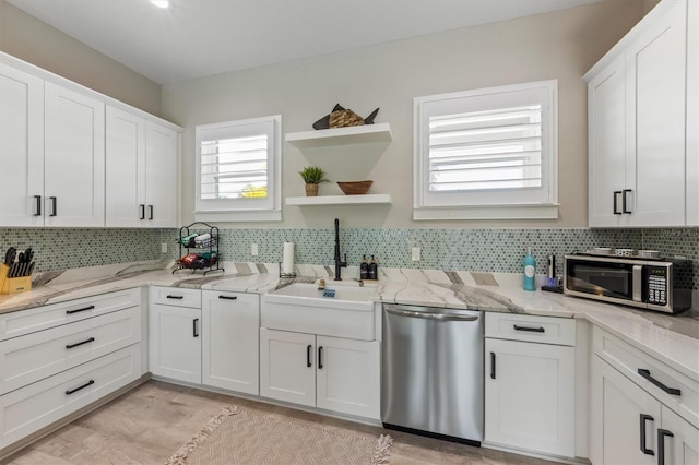 kitchen featuring light stone countertops, sink, stainless steel appliances, tasteful backsplash, and white cabinets