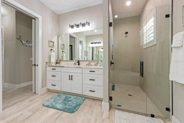 bathroom with hardwood / wood-style flooring, vanity, and walk in shower