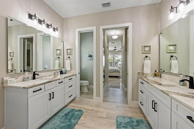 bathroom featuring ceiling fan, toilet, wood-type flooring, and vanity