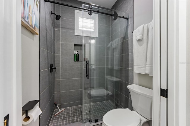 bathroom with a shower with door and toilet