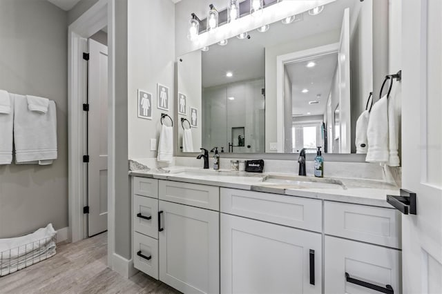 bathroom featuring hardwood / wood-style floors, vanity, and a shower with shower door