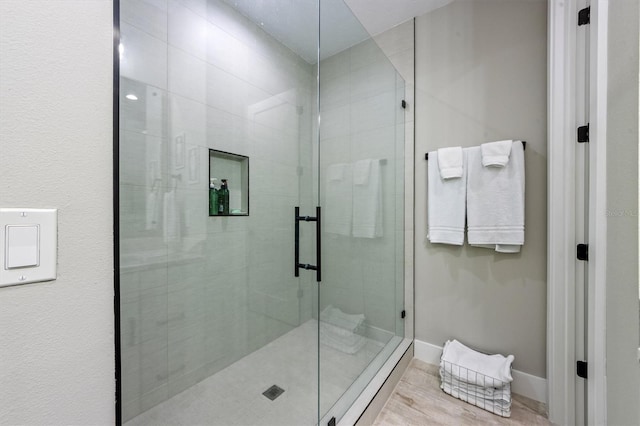 bathroom featuring wood-type flooring and an enclosed shower