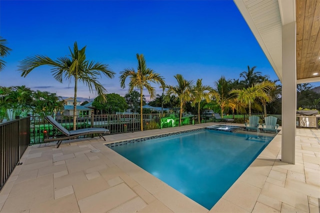 pool at dusk with a patio area