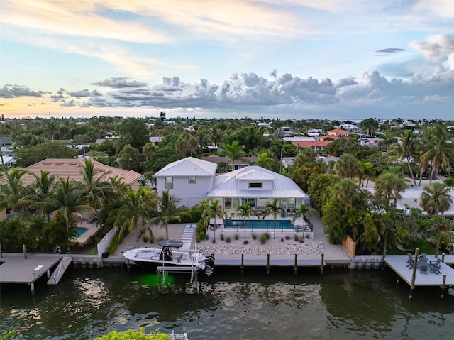 aerial view at dusk featuring a water view