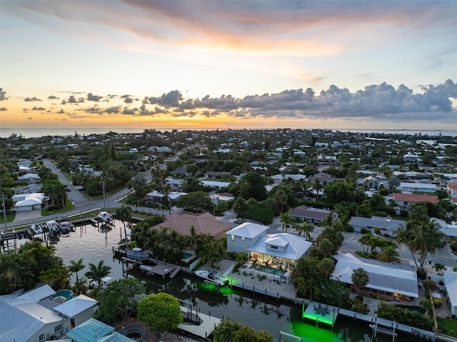 aerial view at dusk featuring a water view