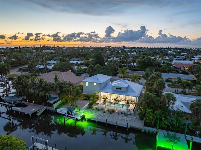 aerial view at dusk featuring a water view