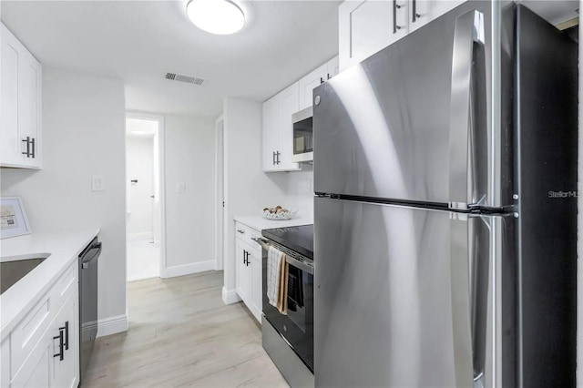 kitchen featuring white cabinetry, stainless steel appliances, and light hardwood / wood-style floors