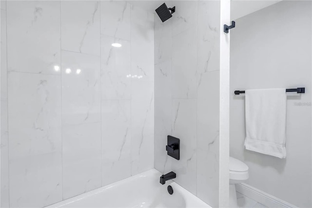 bathroom featuring tiled shower / bath combo and toilet