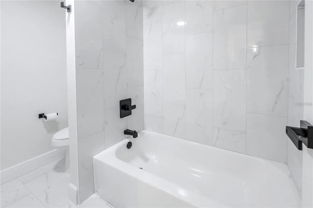 bathroom featuring toilet and tiled shower / bath