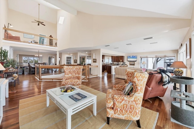 living room with high vaulted ceiling, wood-type flooring, and ceiling fan with notable chandelier