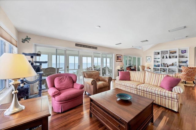 living room with dark hardwood / wood-style flooring, plenty of natural light, and a water view