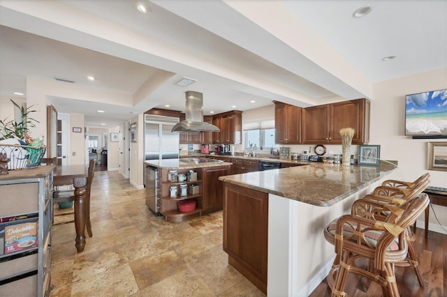 kitchen featuring sink, stainless steel appliances, kitchen peninsula, dark stone countertops, and island range hood