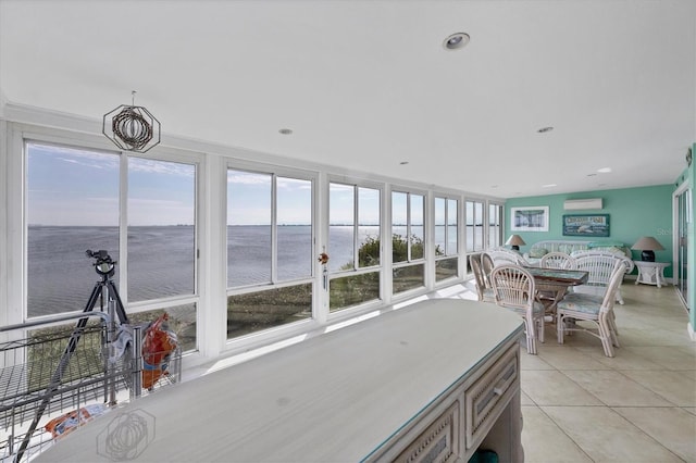 sunroom featuring a wall mounted air conditioner and a water view