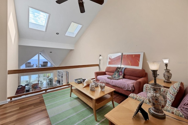 living room with wood-type flooring, a skylight, high vaulted ceiling, and ceiling fan