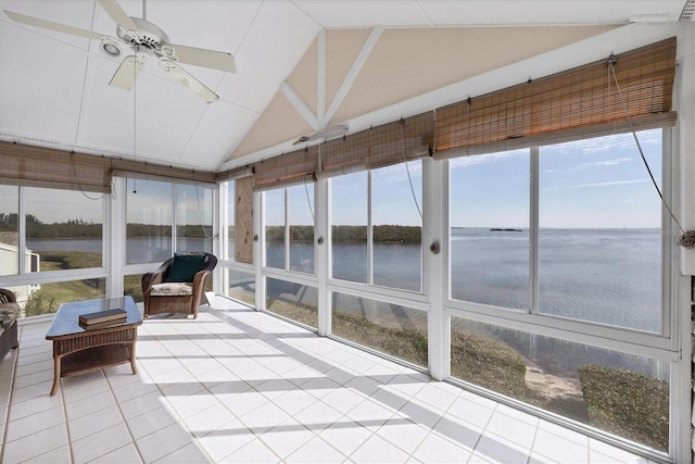 sunroom with ceiling fan, a water view, and lofted ceiling